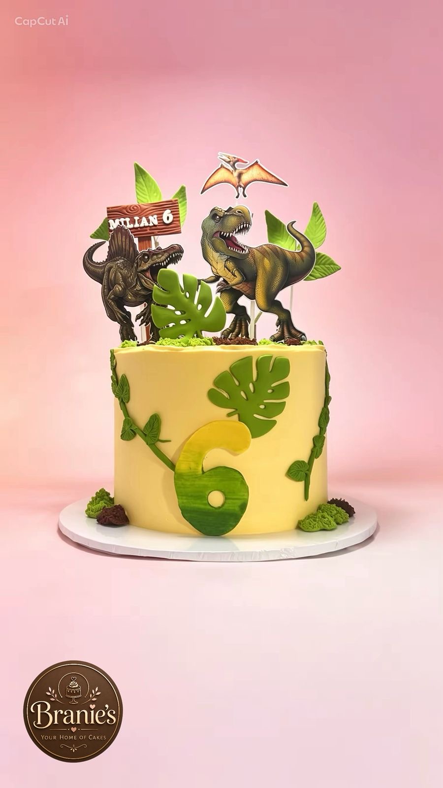 Dinosaur themed birthday cake with jungle leaves
